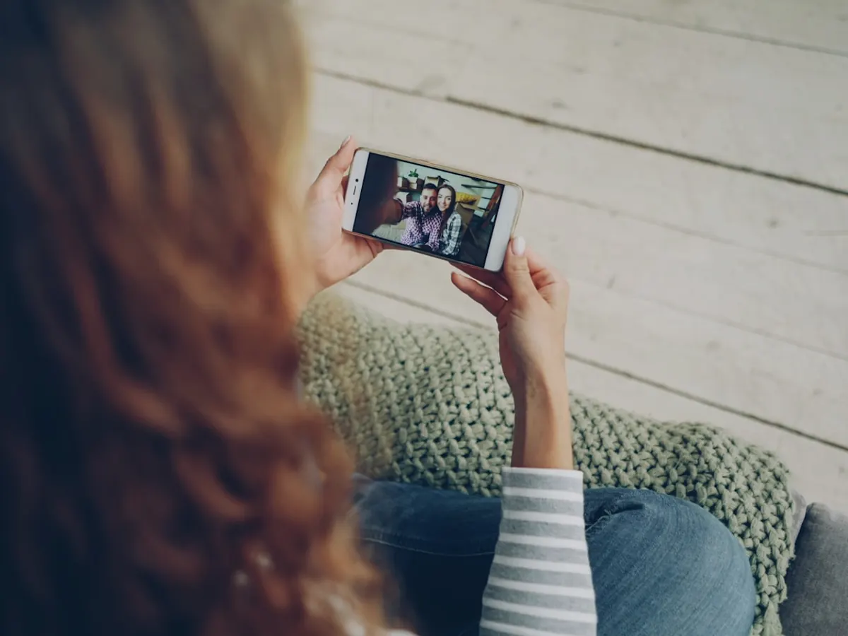 Person watching video on a mobile phone at home
